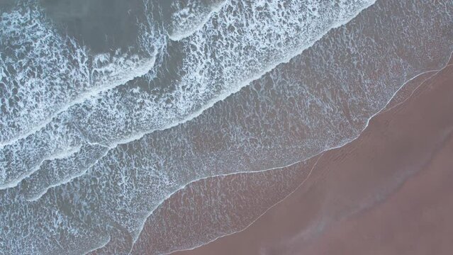 4K aerial view of calm ocean waves and sandy beach in Mandvi, Kutch, India. Top down view over ocean coast. Serene and Tranquil Landscape of beach.