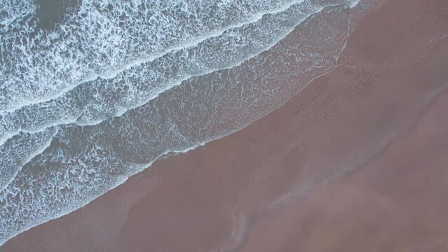 4K aerial view of calm ocean waves and sandy beach in Mandvi, Kutch, India. Top down view over ocean coast. Serene and Tranquil Landscape of beach. Travel and summer holidays concept