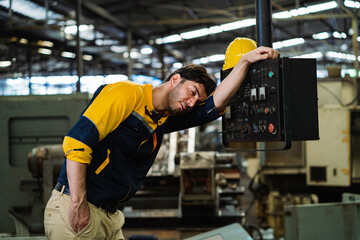 Tired engineer working hard in industrial factory. Tired male worker in a hot factory. stress and hard work