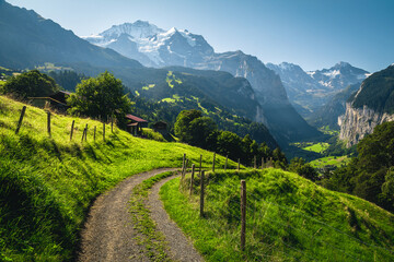 Curved rural road on the slope in Lauterbrunnen valley, Switzerland - 609693430