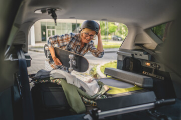 mature blonde woman travel take stuff belongings from the back of car