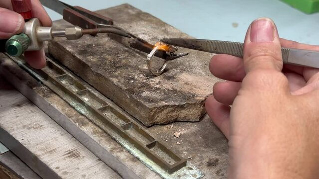 Jeweler soldering prongs onto a diamond ring 