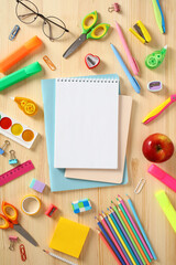 Blank paper notepad with school supplies on wooden table. Back to school concept