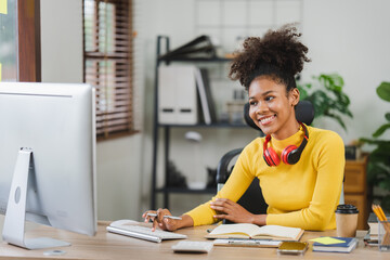 Young African American freelancer working on computer in home office. Female college student.