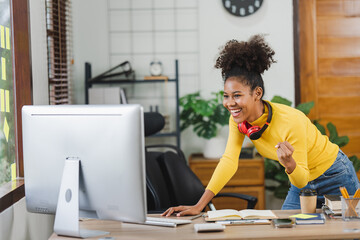 Young African American freelancer smiling excitedly at the success of her job. young woman working on computer in home office