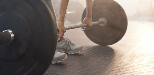 Fototapeta na wymiar Fitness, woman in gym and barbell for weightlifting, power and muscle with closeup on equipment at sports club. Balance, strength and female bodybuilder lifting weights and training with health goals