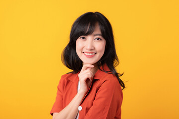 Portrait young beautiful asian woman happy smile dressed in orange clothes showing thinking gesture isolated on yellow studio background.