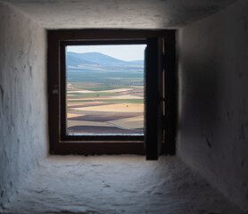 Crop fields of Castilla-La Mancha (Spain) seen through a square wooden window