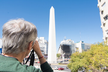 Photographer taking photo at 9 de Julio Avenue and Obelisk in Buenos Aires, Argentina