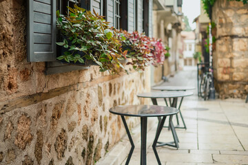 Fototapeta na wymiar Cafe on a quiet street at the city of Antalya, Turkiye. Leisure and travel to popular tourist destinations.