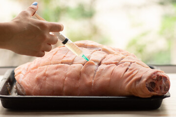 Chef Injecting brine into pork leg