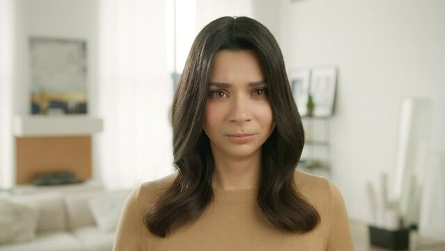 Series of face emotions close up. Upset female face of sad stressed hispanic girl standing indoors looking at camera with resentful offended facial expression worry about trouble problem, broken heart