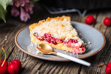 Tart with sour cherry creme, creme patisserie and crumbs, served with vanilla ice cream. Rustic and moody atmosphere and decoration. 