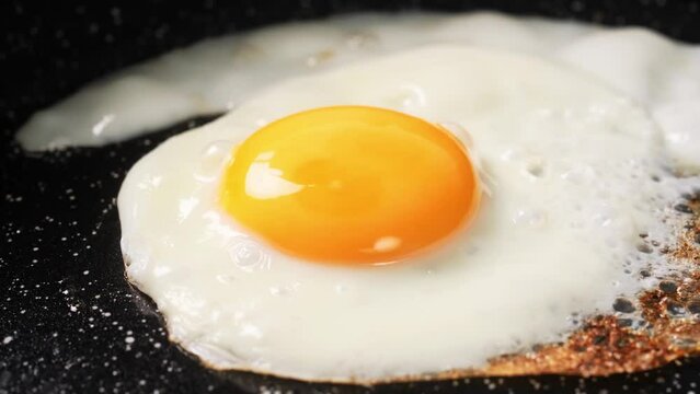 Fried egg. Chicken egg is fried in a frying pan close-up video 4k