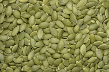 Green pumpkin seeds background. Top view