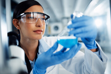 Woman, scientist and study chemical liquid, glass beaker and science chemistry experiment in lab. Female doctor with goggles, gloves and analysis of fluid, scientific innovation and medical research
