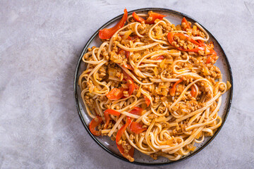 Close up of udon noodles with soy meat and vegetables on a plate on the table top view
