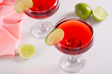 Alcoholic cosmopolitan cocktail in glasses and lime on the table