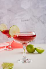 Cosmopolitan cocktail with lime in glasses on the table vertical view