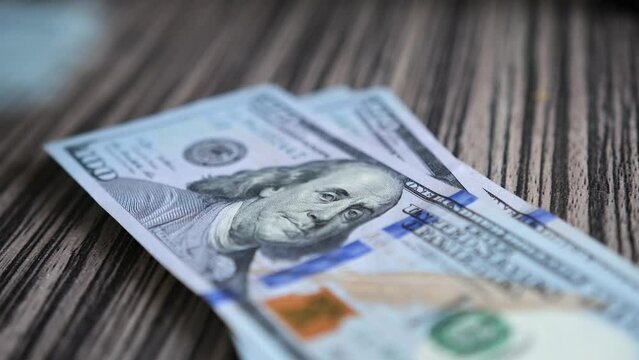 Male hands fast counts dollars bill money and put on the table, close up. Hundred dollar on the table with money. Usa Dollars money.