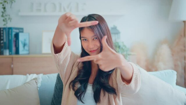 Happy young asian woman hands making frame shape and looking in camera, Lovely female having fun posing in creative way.