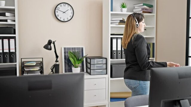 Young blonde woman business worker wearing headset speaking at office
