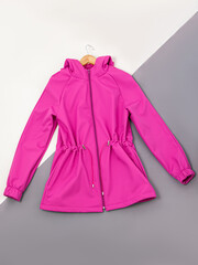 Women's pink jacket or windbreaker on white and gray background. Top view © Svetlana