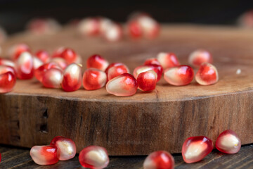 Red pomegranate seeds on the table and the board