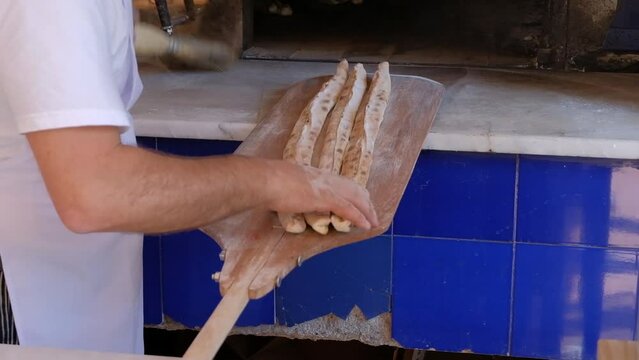 Bafra style pide which is a Turkish pizza with meat in a closed bread is placed in a traditional oven heated by wood