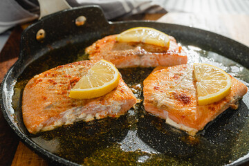 Salmon slices fried with seasoning, smoked paprika, and lemon slices