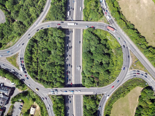 Aerial high drone in 4K flight over road traffic. Highway and overpass with cars and trucks, interchange, two-level road junction in the big city. Top view. 