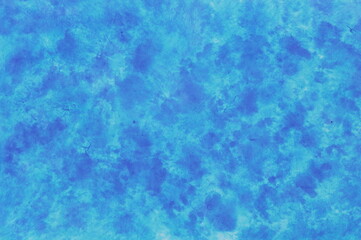 Fototapeta na wymiar Speckled background of paper colored in shades of blue