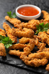 Crispy Shredded Chicken with sweet chilli sauce served on black slate. Party finger food snack concept