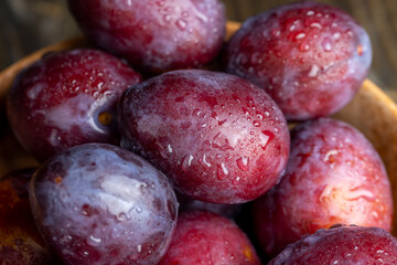 Ripe plums of dark color on the table