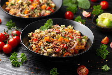 Red and white quinoa tabbouleh salad with tomatoes, paprika and mint. Vegetarian, vegan food concept