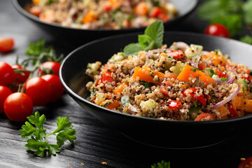 Red and white quinoa tabbouleh salad with tomatoes, paprika and mint. Vegetarian, vegan food concept