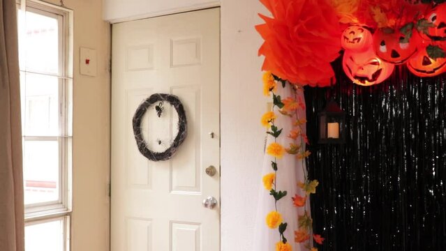Spooky decoration for Halloween. Dark wreath of dry branches with spiderwebs hanging on the door. Full shot. 