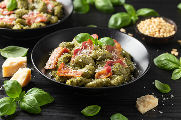 Italian potato gnocchi with green pesto sauce, bacon and parmesan cheese. Healthy food