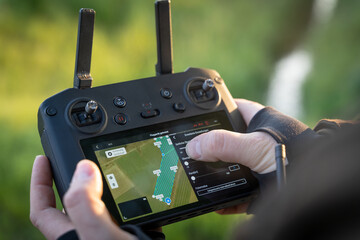Rehkitzrettung - Fernbedienug einer Drohne zeigt auf den Bildschirm an, ob ein Kitz in der Wiese...