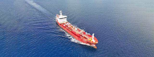 Aerial drone ultra wide photo of small oil - chemical tanker cruising in deep blue open ocean sea