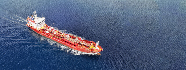 Aerial drone ultra wide photo of small oil - chemical tanker cruising in deep blue open ocean sea