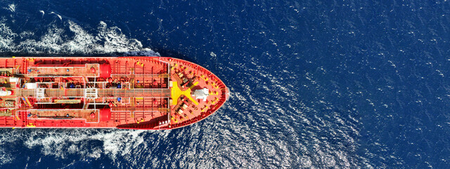 Aerial drone ultra wide photo of small oil - chemical tanker cruising in deep blue open ocean sea