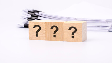 three wooden cube with question marks on white background