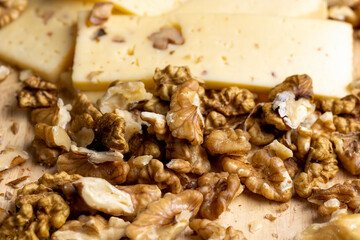 Sliced piece of milk cheese with walnuts