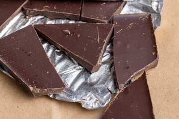 A broken chocolate bar in a paper and foil package