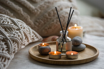 Apartment natural aroma diffusor with sea breeze fragrance. Burning candles on bamboo tray, cozy...