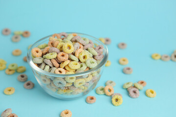 Multicolored corn rings for breakfast on a colored background
