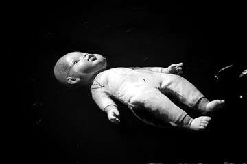 An abandoned doll floating in a pond