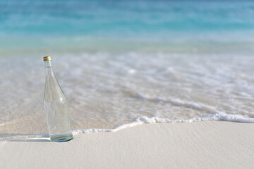Glass bottle of pure water on the background of ocean