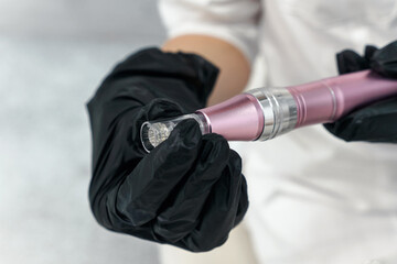 Dermis stamp electric pen. Dermapen. Needle mesotherapy treatment close up in cosmetologist hands...